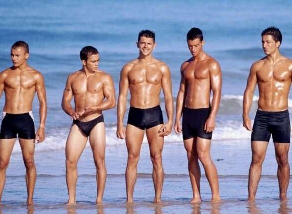 Hombres en la playa con colas agrandadas